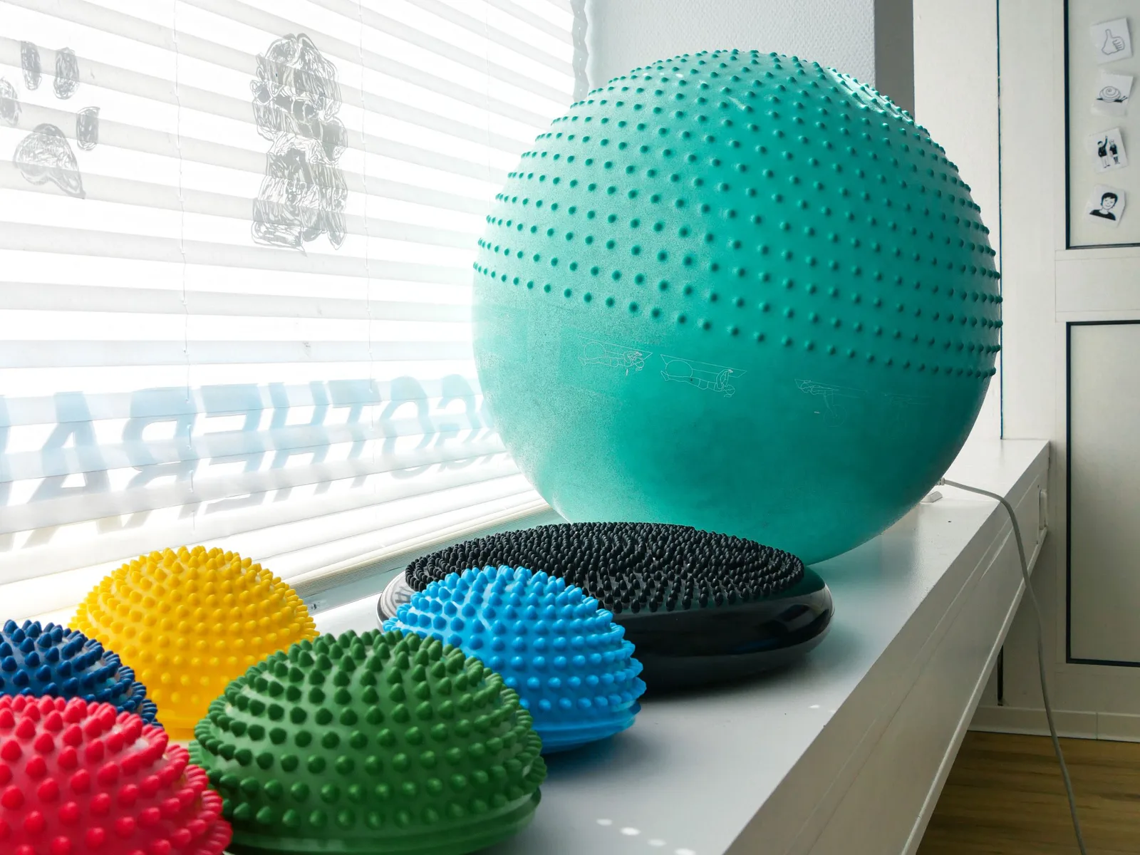 Großer Igelball und bunte Balancehalbkugeln auf einer Fensterbank