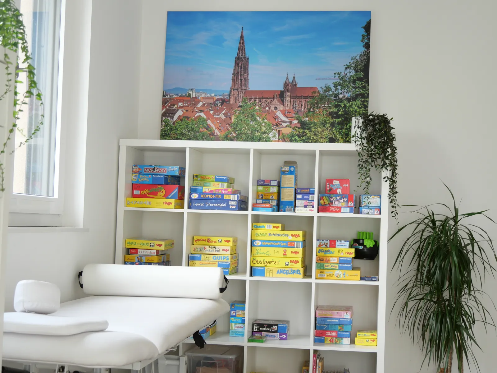 Behandlungsraum einer Therapiepraxis mit Liege und Materialregal