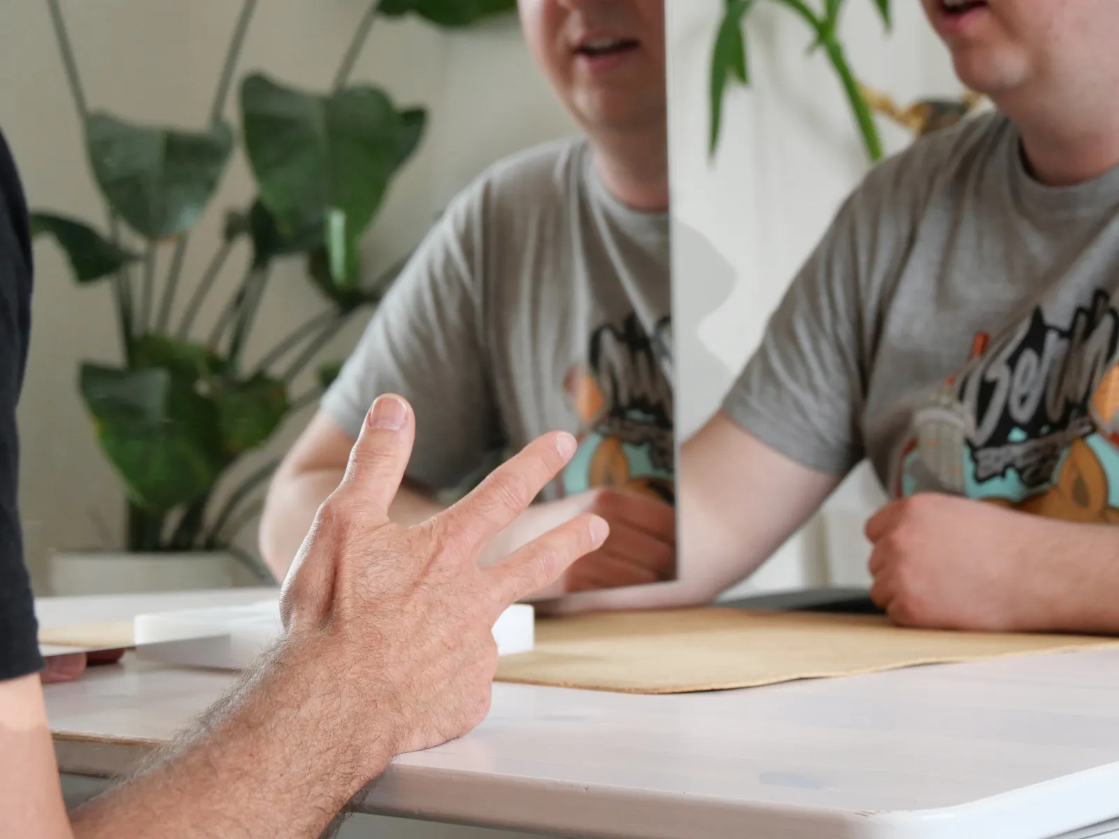 Therapeut erklärt einer Kollegin etwas am Tisch (kollegiale Besprechung)